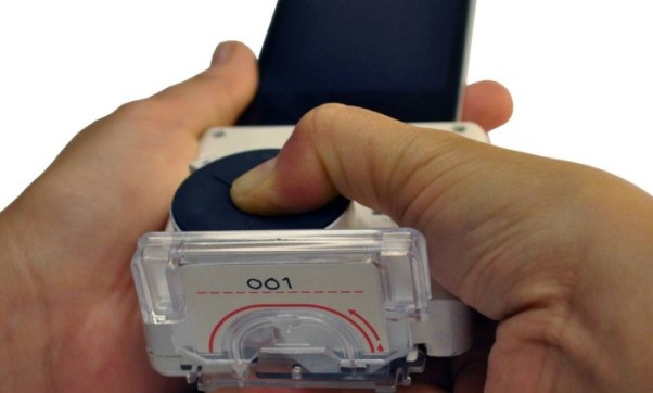 Usuário pressiona o acessório ligado ao celular para ativar reagentes - Divulgação/Tassaneewan Laksanasopin/Universidade de Columbia